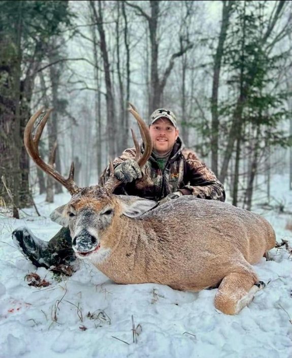 Man with buck in snow
