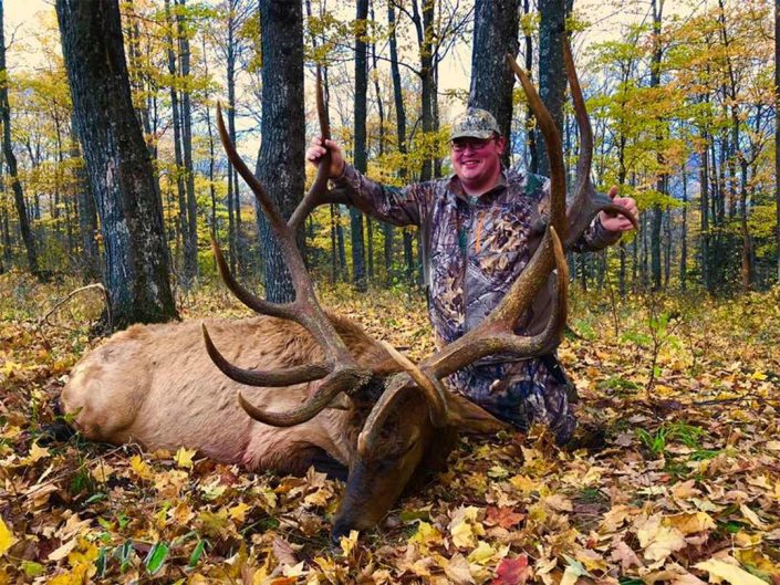 a hunter poses with his trophy elk kill 