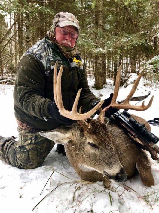 someone poses with a trophy whitetail deer