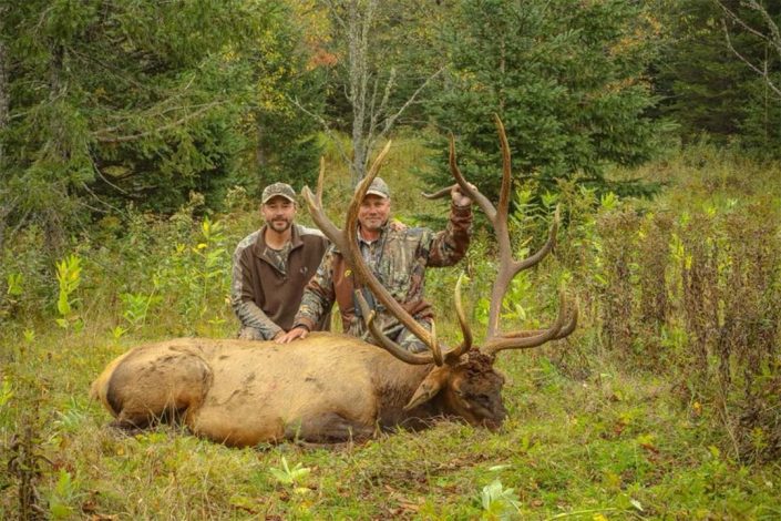 two hunters with a trophy bull elk 