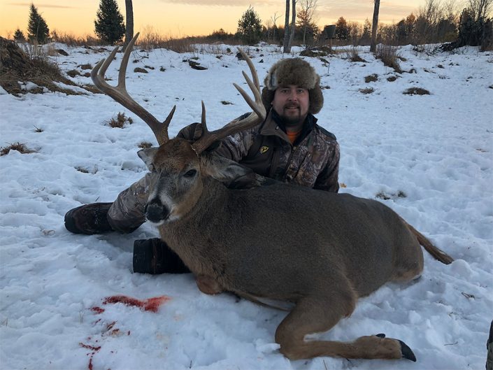 someone posing with a whitetail trophy