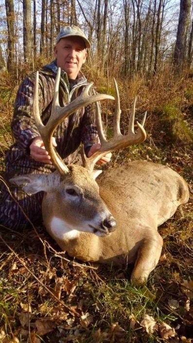 a hunter shows off a large elk 