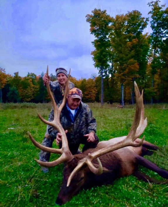 two hunters show off the antlers on an elk 