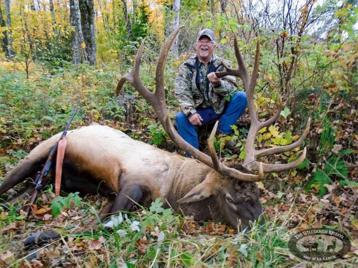a hunter with the elk he has hunted 