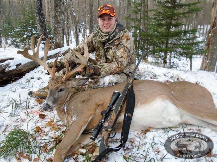 A man shows off the buck he has hunted 
