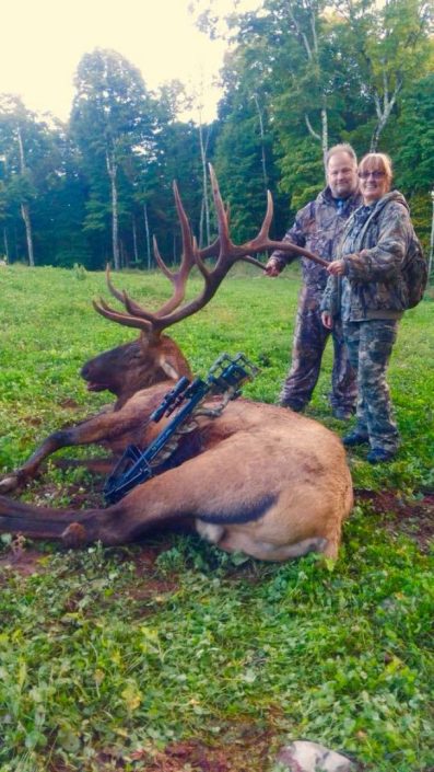 a couple show off an elk and their compound bow 