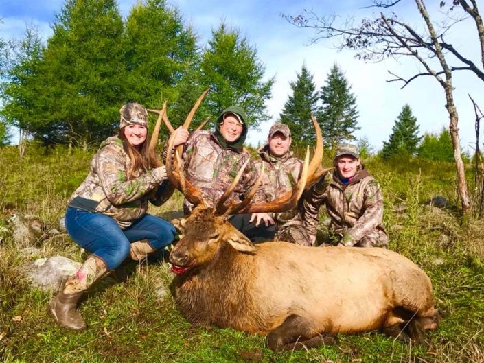 a group shows off their elk kill 