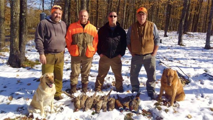 a group posses with some pheasants they have harvested