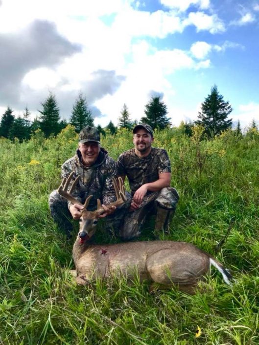 two hunters with a velvet buck 