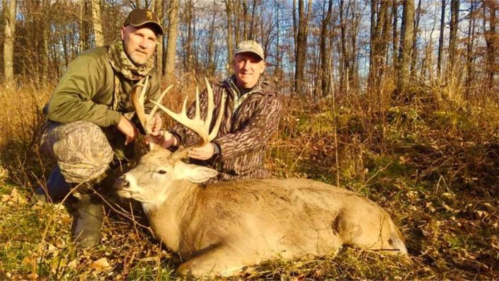 a pair show off their downed whitetail deer