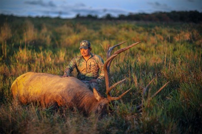 a man poses with his elk trophy 