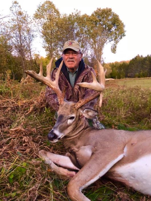 a man shows off his whitetail trophy 