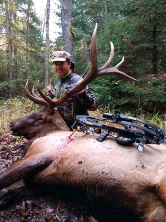 a bowhunter shows off his elk kill 