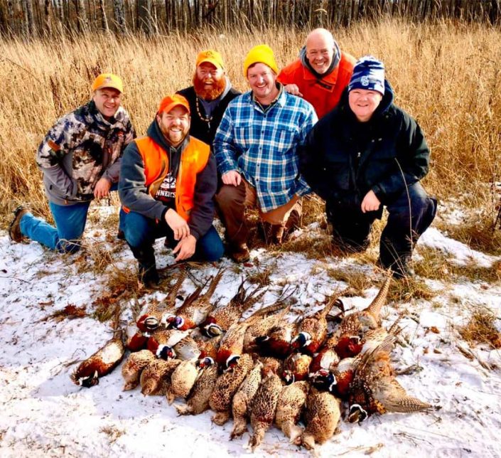 a group pose with their pheasant harvest