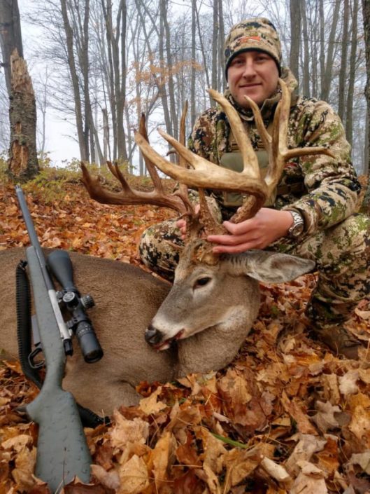 someone posing with a trophy whitetail deer