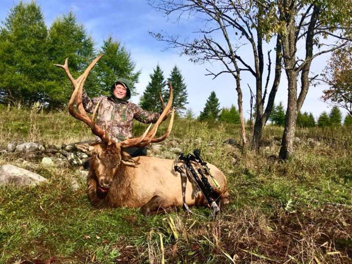 a hunter with an elk bull 