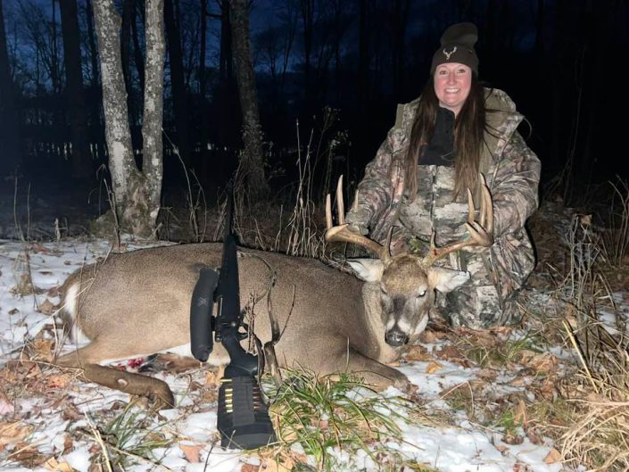 Female hunter and deer at night