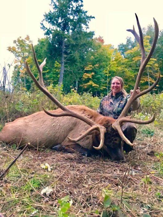 a hunter with an elk with massive antlers 